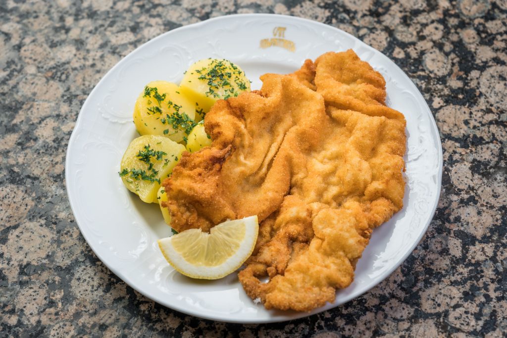 Café Schwarzenberg Wiener Schnitzel mit Petersilien Kartoffeln und einer Zitronenscheibe